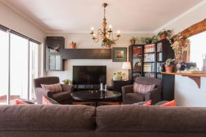 sala de estar con sofá y TV en "HomeySuite" in Estoril Beach Apartment, en Estoril