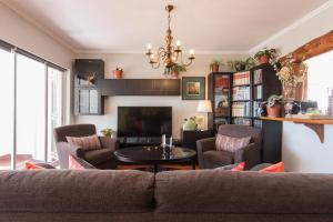 a living room with a couch and a tv at "HomeySuite" in Estoril Beach Apartment in Estoril