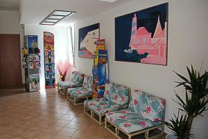 a waiting room with chairs and posters on the wall at Residence Algarve in Rimini