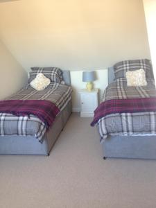 dwa łóżka siedzące obok siebie w sypialni w obiekcie Acorn Apartment w mieście Dufftown