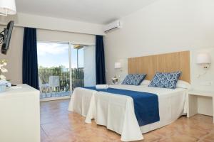 sypialnia z dużym łóżkiem i dużym oknem w obiekcie AluaSun Marbella Park w Marbelli