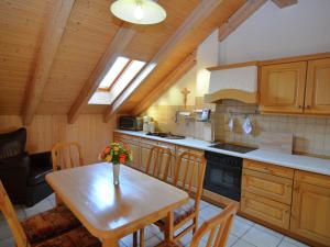 a kitchen with a wooden table and a dining room at Holiday home with panoramic view and every convenience spa in Waldkirchen