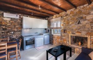 a kitchen with a stone wall and a stove top oven at Avrofilito Syros Houses in Ermoupoli