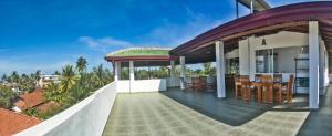 an outdoor patio of a villa with a dining area at Ravi Villa Hikkaduwa in Hikkaduwa