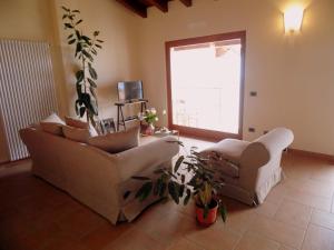 - un salon avec deux chaises blanches et une fenêtre dans l'établissement Belvilla by OYO Belvedere, à Marone
