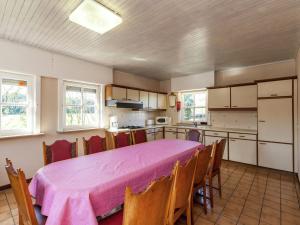 una cocina con mesa y sillas rosas en Villa with large fenced garden near Bruges and the forest, en Brujas