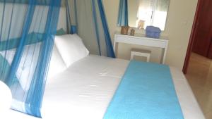 Schlafzimmer mit einem Bett mit blauem Baldachin in der Unterkunft Apartment Katherina Sarande in Sarandë