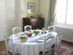 a white table with white chairs and a table with food on it at La Maison de Saumur in Saumur