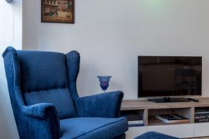a blue chair sitting in front of a television at Suite Home Milano Brera in Milan