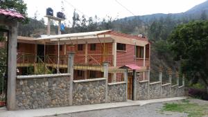 a house with a stone wall in front of it at El Encanto Sorata in Sorata
