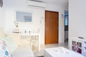 sala de estar con sofá blanco y mesa en Suncity Flat Salitre I en Málaga