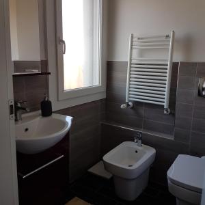 a bathroom with a sink and a toilet and a window at Il Cantuccio B&B in Bologna