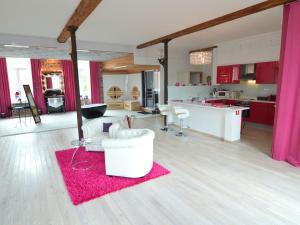 a large kitchen with red cabinets and a pink rug at Lush Apartment in Ensival with sauna in Ensival