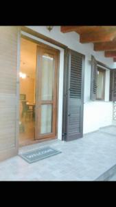una porta aperta per una casa con portico di Appartamento Rosmarino a Buggerru