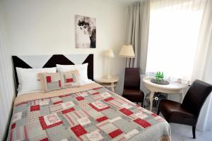 sypialnia z łóżkiem, stołem i krzesłami w obiekcie Hotel Ottaviano w Świnoujściu