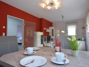 een keuken met een tafel met borden en wijnglazen bij Modern apartment Thuringia in Tabarz