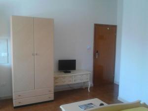 Habitación con escritorio, TV y armario. en Residence Rotonda, en Savignano sul Rubicone