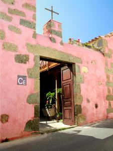 a pink building with a cross on top of it at Casa Rural La Pileta - Bentejui in Agüimes