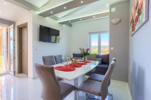 a dining room with a white table and chairs at Apartments VALL in Krk