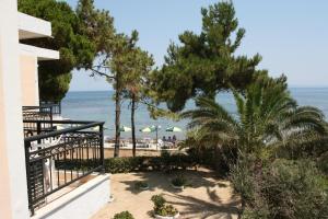 Blick auf einen Strand mit Bäumen und Sonnenschirmen in der Unterkunft Castello Beach Hotel in Argassi