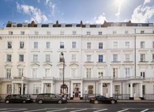 倫敦的住宿－貝爾格拉維酒店，一座白色的建筑,前面有汽车停放