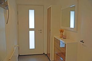 pasillo con puerta y cocina con encimera en Stubai Apartment Telfes, en Telfes im Stubai