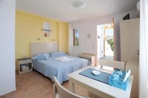 una camera con letto e tavolo e una sala da pranzo di Aigaio Studios tinos a Città di Tinos