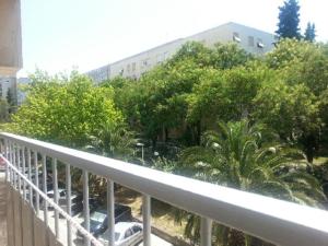 een balkon van een gebouw met bomen en een auto bij Apartment Nina in Split