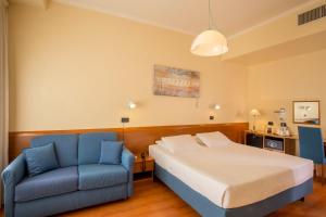 - une chambre avec un lit et un canapé bleu dans l'établissement Best Western Hotel Globus, à Rome