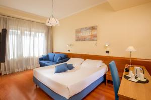 um quarto de hotel com uma cama grande e uma cadeira azul em Best Western Hotel Globus em Roma