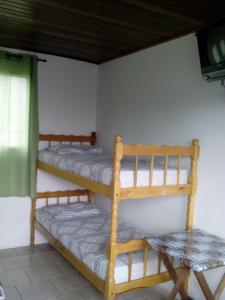 a room with two bunk beds and a window at Hotel Pousada Guaratuba in Guaratuba