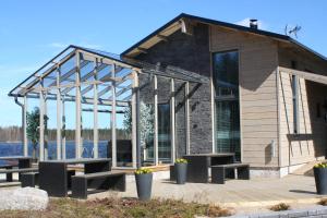 海尔迈Haarusmaa Holiday Apartment Härmä的甲板上设有长椅和桌子的房子