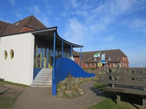 里斯特Jugendherberge List的前面有蓝色滑梯的建筑