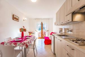 a kitchen with a table with a red table cloth at Apartments Valbandon in Fažana