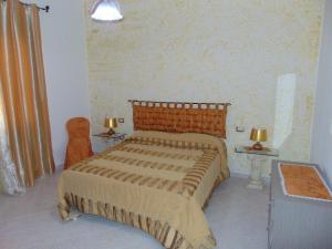 een slaapkamer met een groot bed en 2 lampen bij Appartamenti Budoni in Budoni