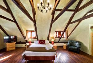 Un dormitorio con una cama grande y una lámpara de araña. en Pension U Hada, en Český Krumlov