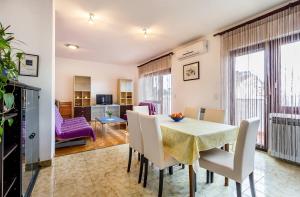 een eetkamer met een tafel en stoelen en een woonkamer bij Apartment Jovanka in Medulin