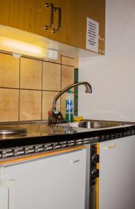 a kitchen sink with a faucet on top of it at Tysfjord Hotel in Storjord I Tysfjord