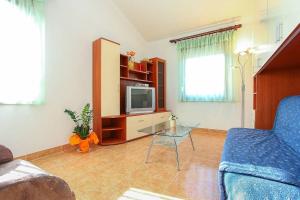 a living room with a blue couch and a tv at Apartments Vlah in Medulin