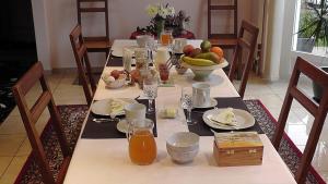 una mesa de comedor con frutas y zumo. en Les Petites Chambres de la Bleue Maison, en Coeuve