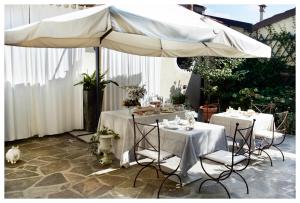 un patio con due tavoli e un ombrellone di Relais Torre Dei Torti - Luxury Bed and Breakfast a Cava Manara