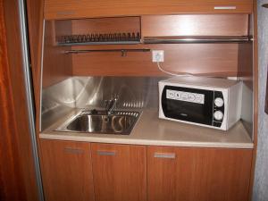 a small kitchen with a sink and a microwave at Hotel Filoxenia in Ouranoupoli
