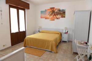 um quarto com uma cama com um cobertor amarelo em B&B Il Canto Del Mare em Pulsano