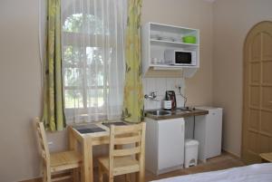 シャールヴァールにあるSárvárfürdő Apartmanházの小さな客室で、キッチン、テーブル、椅子が備わります。