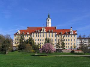 Un gran edificio con una torre de reloj en la parte superior. en Aparthotel Donaustern, en Asbach-Bäumenheim