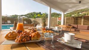 a wooden table with two plates of pastries on it at Villa La Ressource in Le François