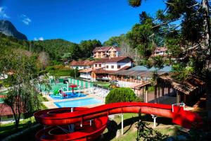 um escorrega de água vermelho em frente a um resort em Pousada dos Pinhos em Pedra Azul