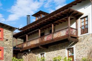 un balcón en el lateral de un edificio en Hotel y apartamentos rurales L'Anceo en Cibuyo