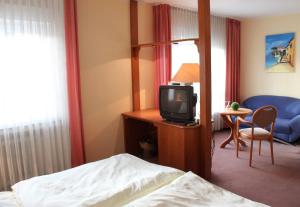 a hotel room with a bed and a tv at Hotel Niederée in Bad Breisig