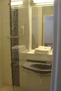 La salle de bains est pourvue d'un lavabo et d'un miroir. dans l'établissement ibis Budget Thiers, à Thiers